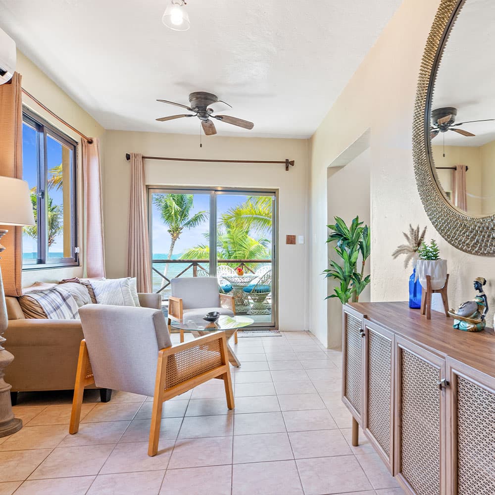 Bright, airy living space with coastal view and tropical decor.